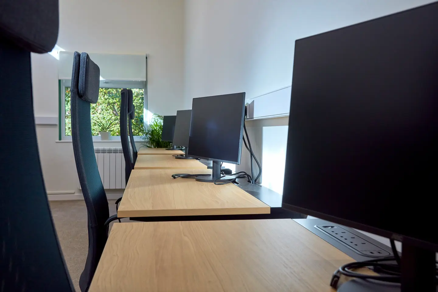 A row of desks with monitors at Pershore Coworking