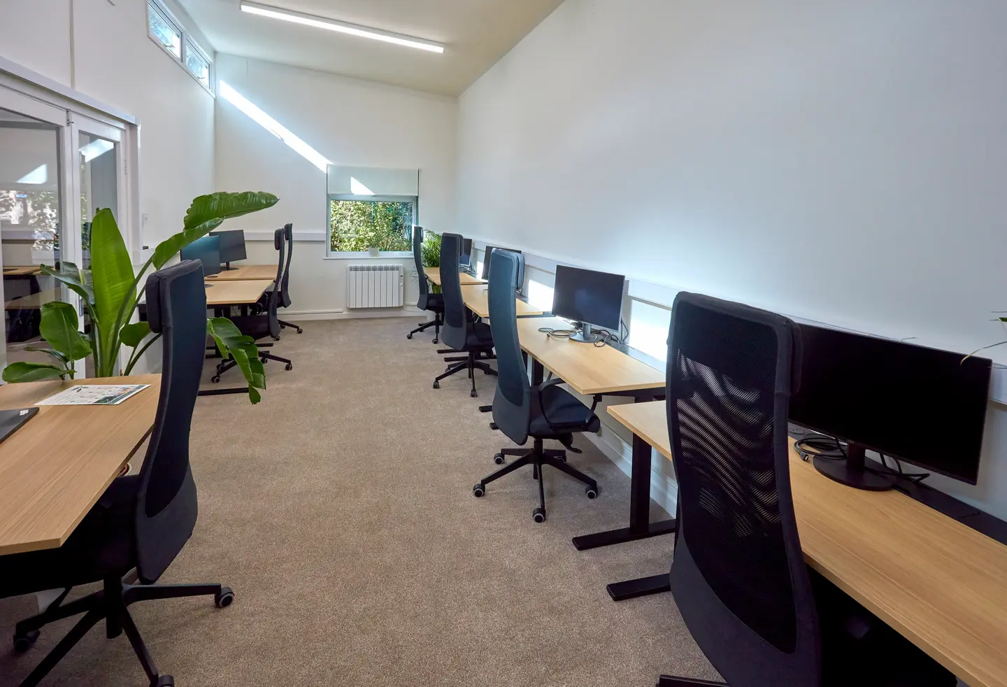 The shared workspace at Pershore Coworking, with rows of desks, monitors, and office chairs